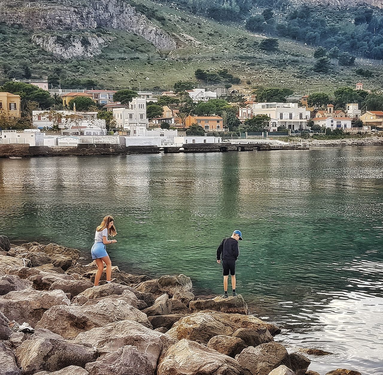 PEOPLE BY SEA AGAINST BUILDINGS