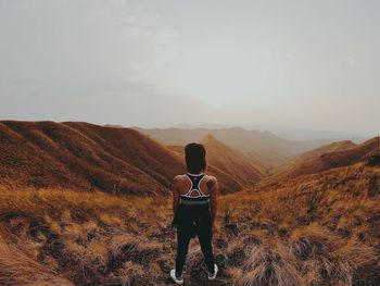 Rear view of man standing on mountain road