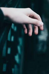 Close-up of cropped hand on railing