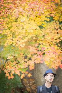 Man by autumn tree