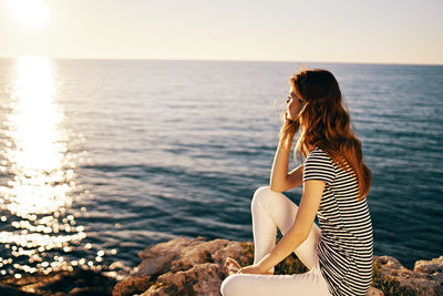 Woman looking at sea against sky