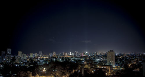 Illuminated cityscape against sky at night