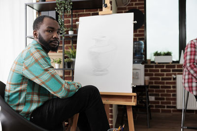 Side view of young man working at home