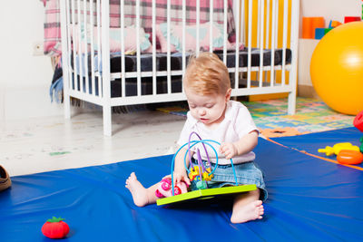 Cute boy playing with toy on floor