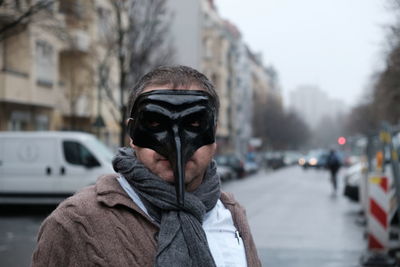 Portrait of man wearing mask on street in city