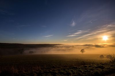 Scenic view of field against sky during sunset