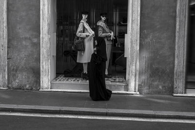 Woman with umbrella standing in city