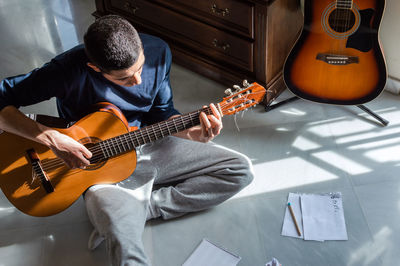 High angle view of man playing guitar