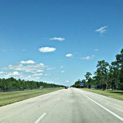 Empty road along trees