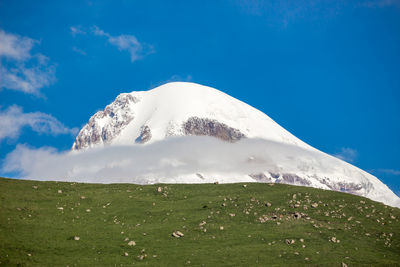 Scenic view of snowcapped mountains against blue sky