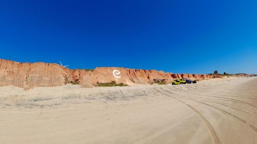 Scenic view of desert against clear blue sky