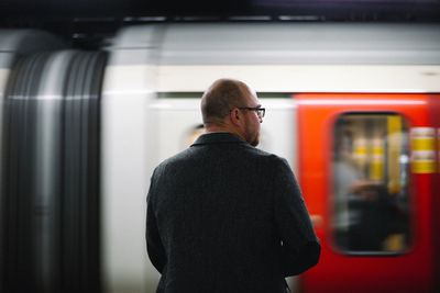 Rear view of man and train at railroad station