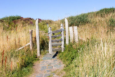 Wooden fence on field against clear sky