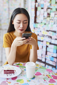 Young woman using mobile phone in cafe