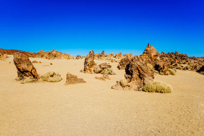 Scenic view of desert against clear blue sky