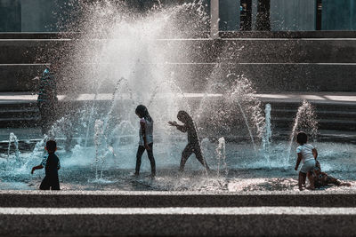 Children enjoying at water fountain