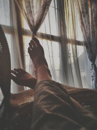 Rear view of a woman looking through window