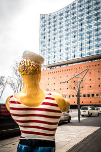 Rear view of woman standing against buildings