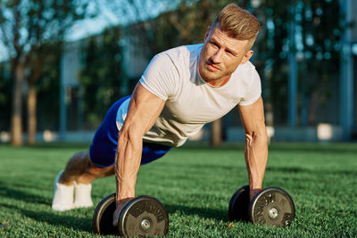 Portrait of man exercising on field