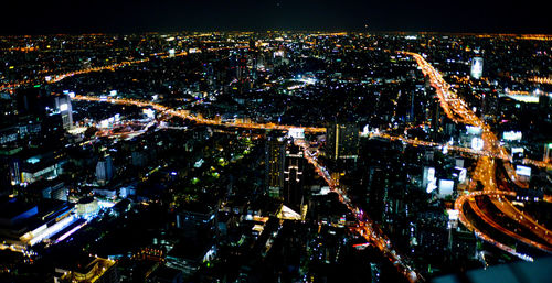 High angle view of city lit up at night