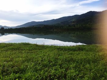 Scenic view of lake by landscape against sky