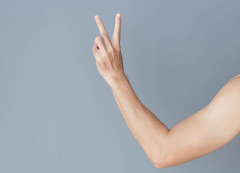 Close-up of person hand against blue background