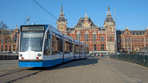 Tram driving in front of the central station in amsterdam the netherlands