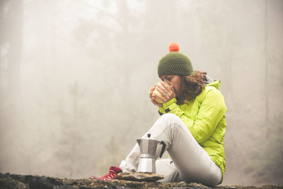 Woman sitting in park during winter