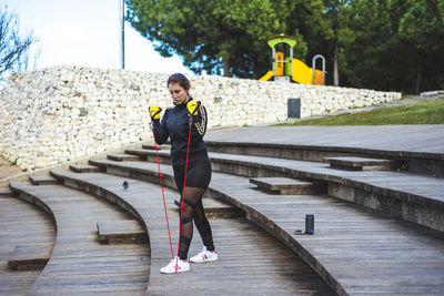 Woman exercising with resistance band on staircase