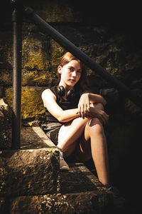 Portrait of young woman sitting on rock