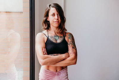 Portrait of woman standing against wall