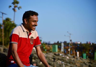 Mid adult man against clear blue sky