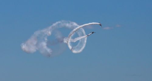 Low angle view of airshow against sky