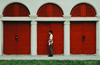 Rear view of woman standing against wall