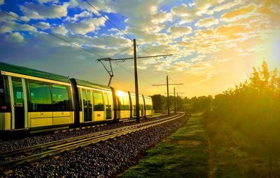 Railroad tracks against sky during sunset