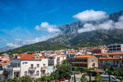 Town by mountains against blue sky