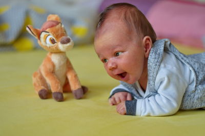 Closeup of cute newborn baby playing with stuffed toy