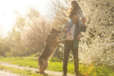 Side view of young woman with dog on field