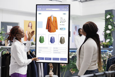 Rear view of woman using digital tablet in office