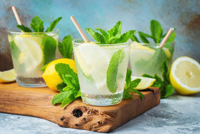 Two glass with lemonade or mojito cocktail with lemon and mint, cold refreshing drink.