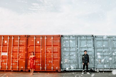 Men standing at bus against sky