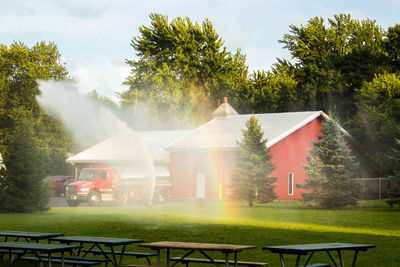 Rainbow on grassy field against fire station