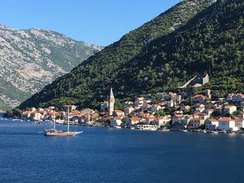 Scenic view of sea and mountains against clear blue sky