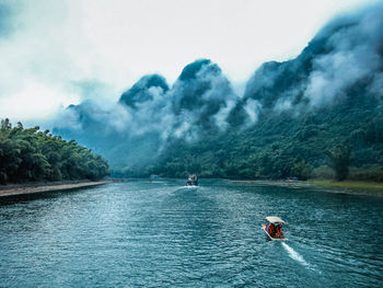 Scenic view of li river against mountains