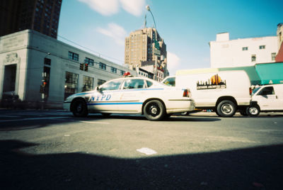 Cars on street against buildings in city