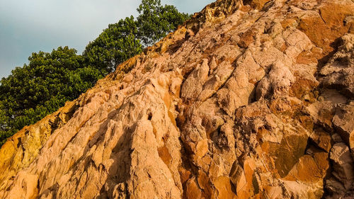 Low angle view of rock formation on land against sky