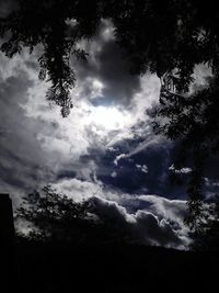 Silhouette of trees against cloudy sky