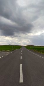 Empty road against cloudy sky