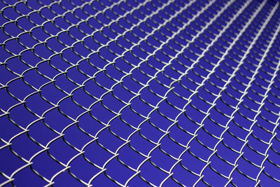 Full frame shot of chainlink fence against clear blue sky