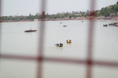 People sailing on river against sky